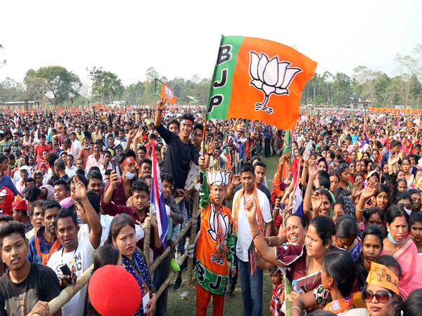 bjp supporters hold party flags during an election rally of prime minister narendra modi