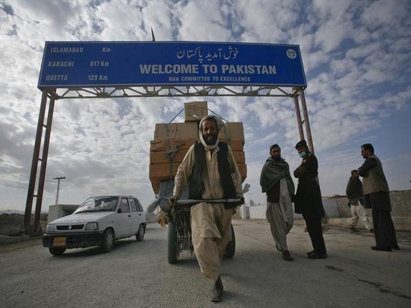 a pashtun man passes a road sign while pulling supplies towards the pakistan afghanistan border crossing in chaman