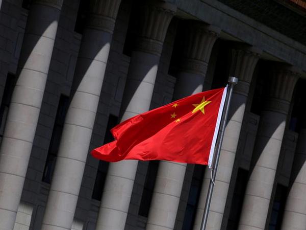 chinese flag flutters in front of the great hall of the people in beijing